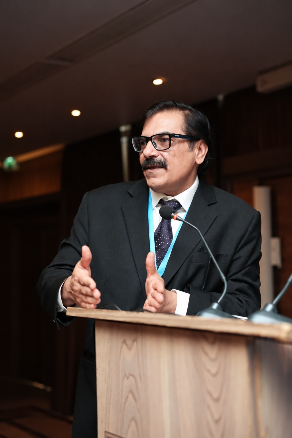 Dr. Mobushir Riaz Khan speaking at a podium